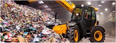 Погрузчик загружает мусор с объекта демонтажа